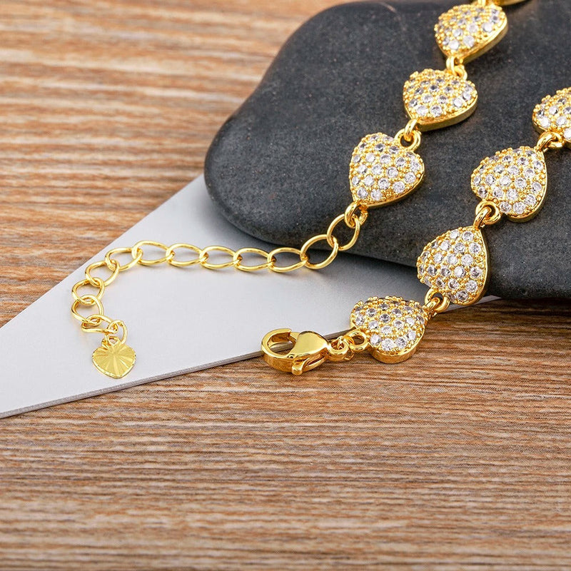 PULSERA DE CORAZONES CON TACHUELAS CHAPADA EN ORO 18K - PLS 125